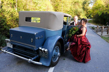 Load image into Gallery viewer, Custom &#39;Wine Red&#39; size 10 used wedding dress side view on bride with car
